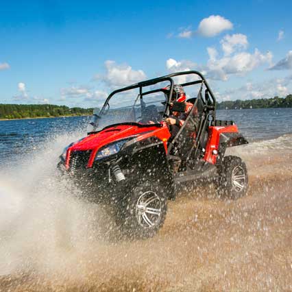 person in ATV on shore of lake